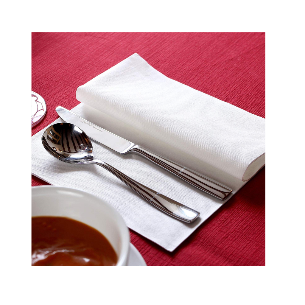 White airlaid napkins on table with cutlery setting.
