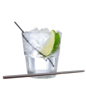 A mini plastic toothpick straw in a short tumbler with water, ice and lemon slice.