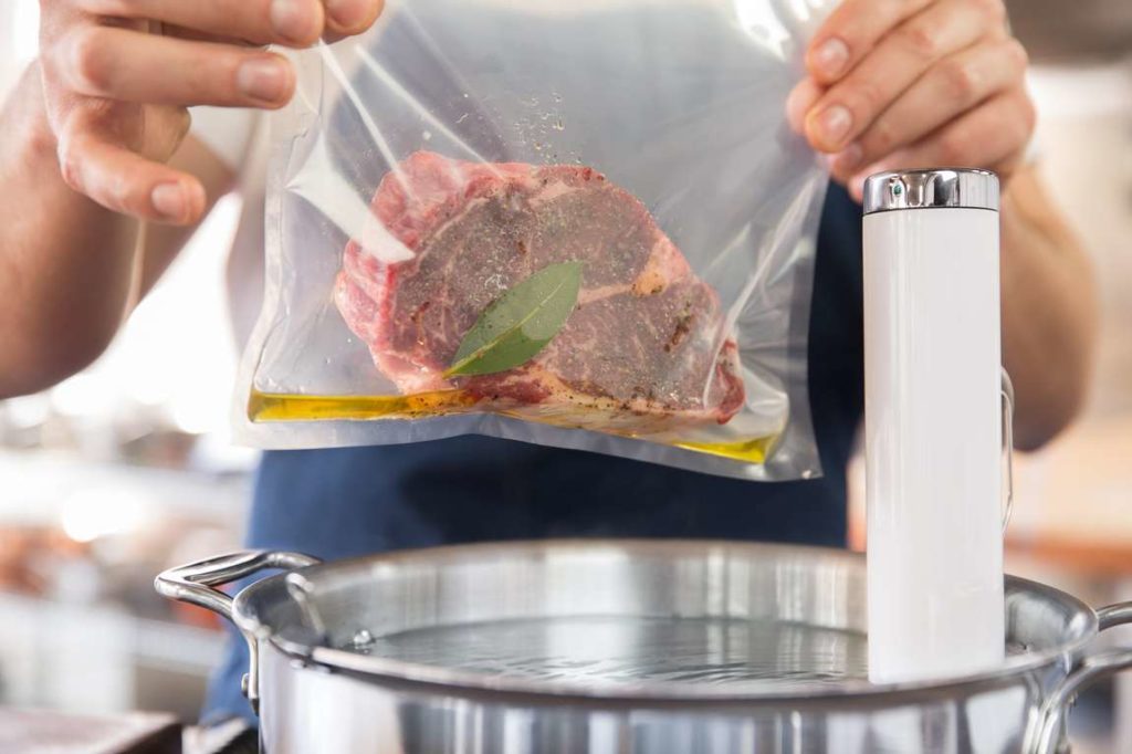 Steak in a vacuum-sealed bag getting prepared to be cooked sous vide.